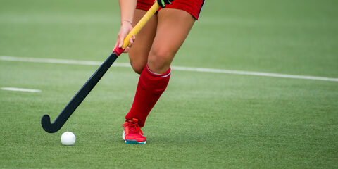 hockey player woman with ball in attack playing field hockey game