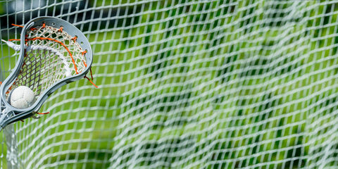 Abstract view of a lacrosse stick scooping up a ball