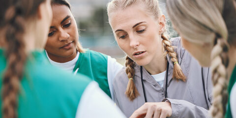 Leader, sports coach or team planning tactics or strategy in a hockey training game, conversation or match. Women, talking or athletes in practice for fitness exercise together for teamwork in group.